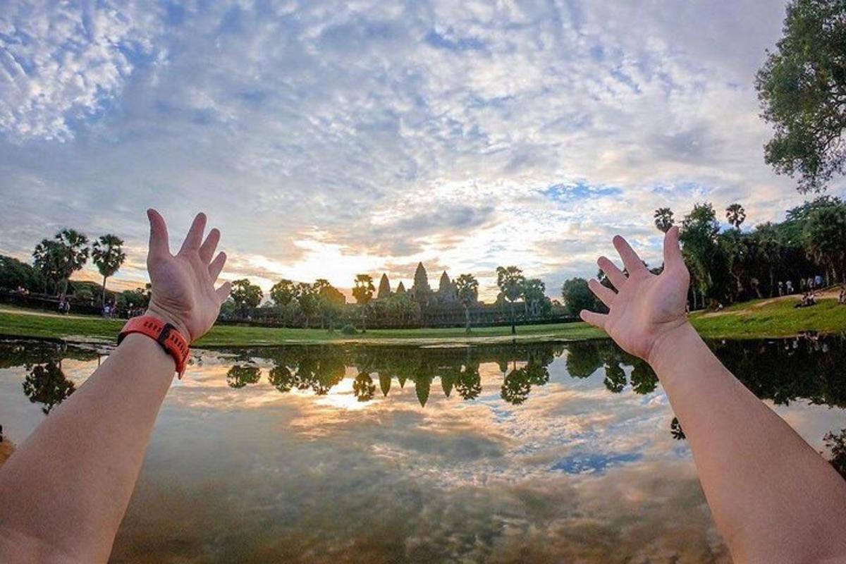 một người giơ tay lên cao trên mặt hồ