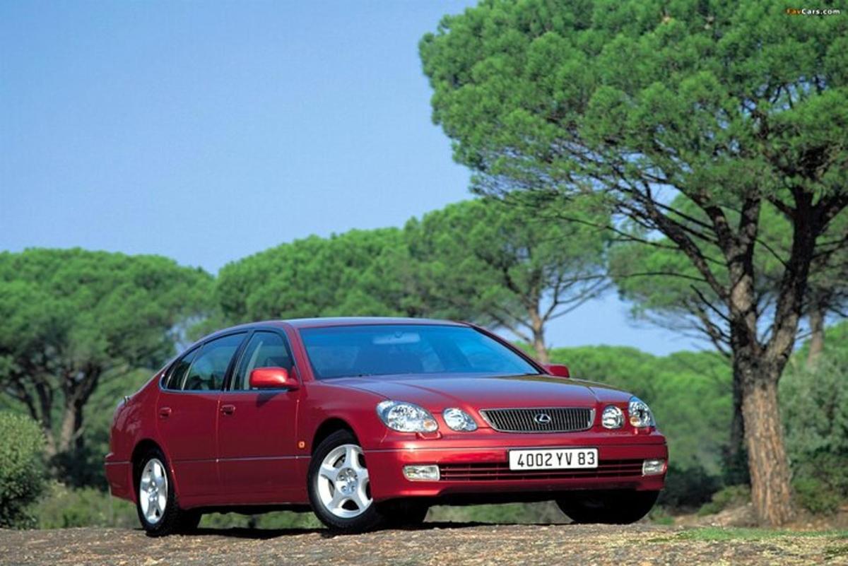 červené auto zaparkované před stromem