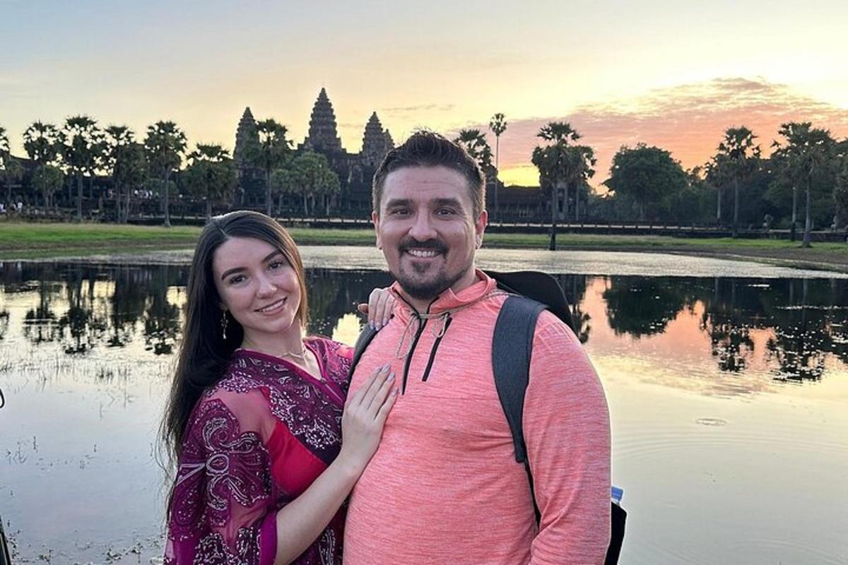seorang lelaki dan seorang wanita berdiri di hadapan sebuah tasik