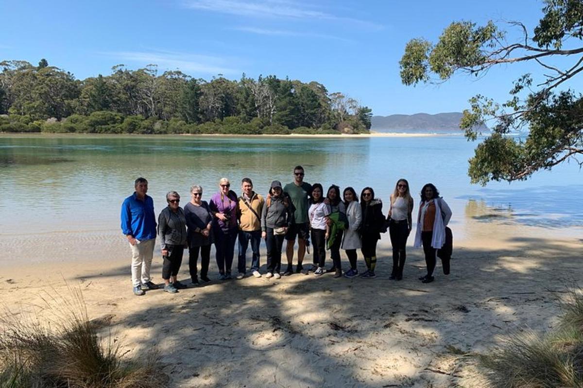Un grupo de personas de pie en una playa cerca del agua.