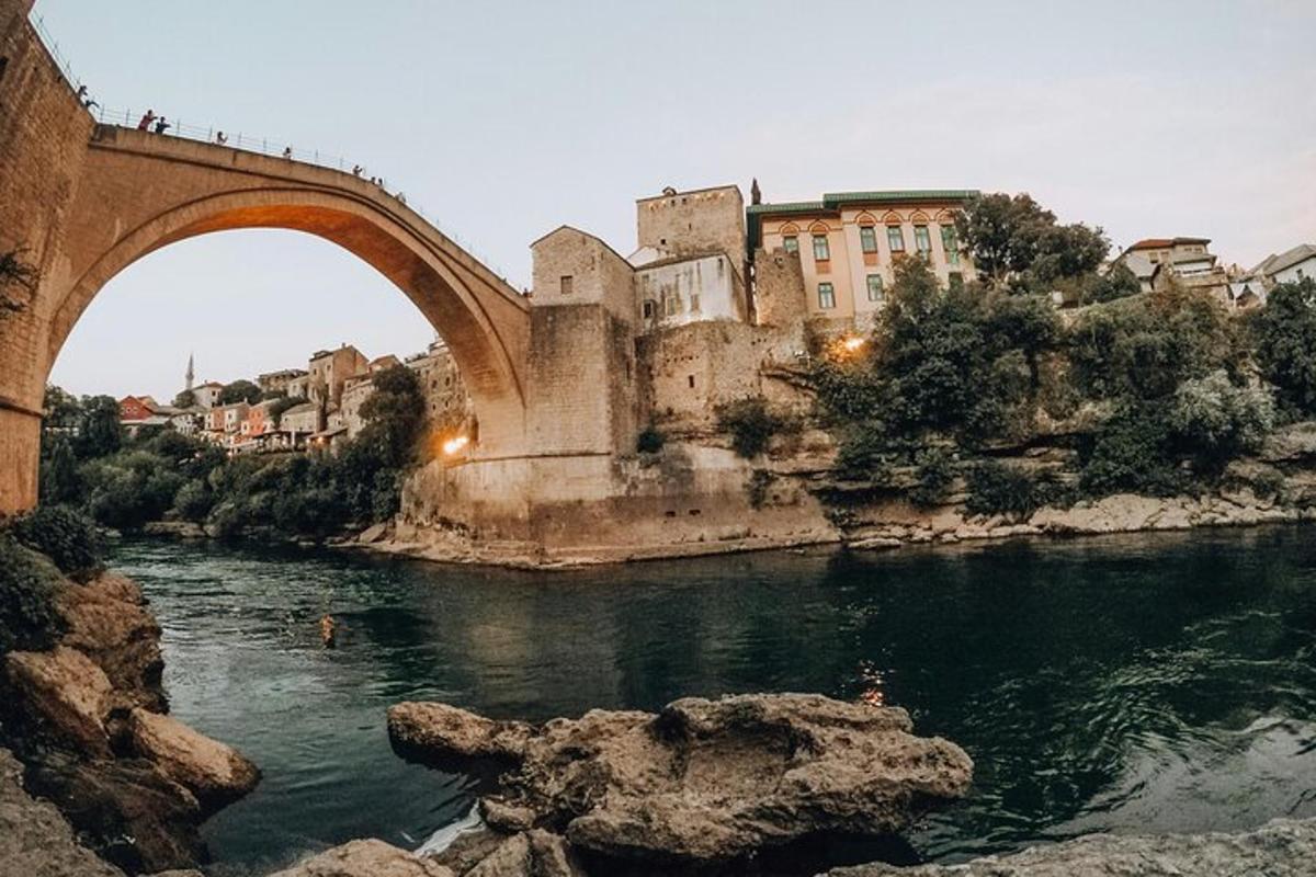 un pont antic sobre un riu amb una ciutat