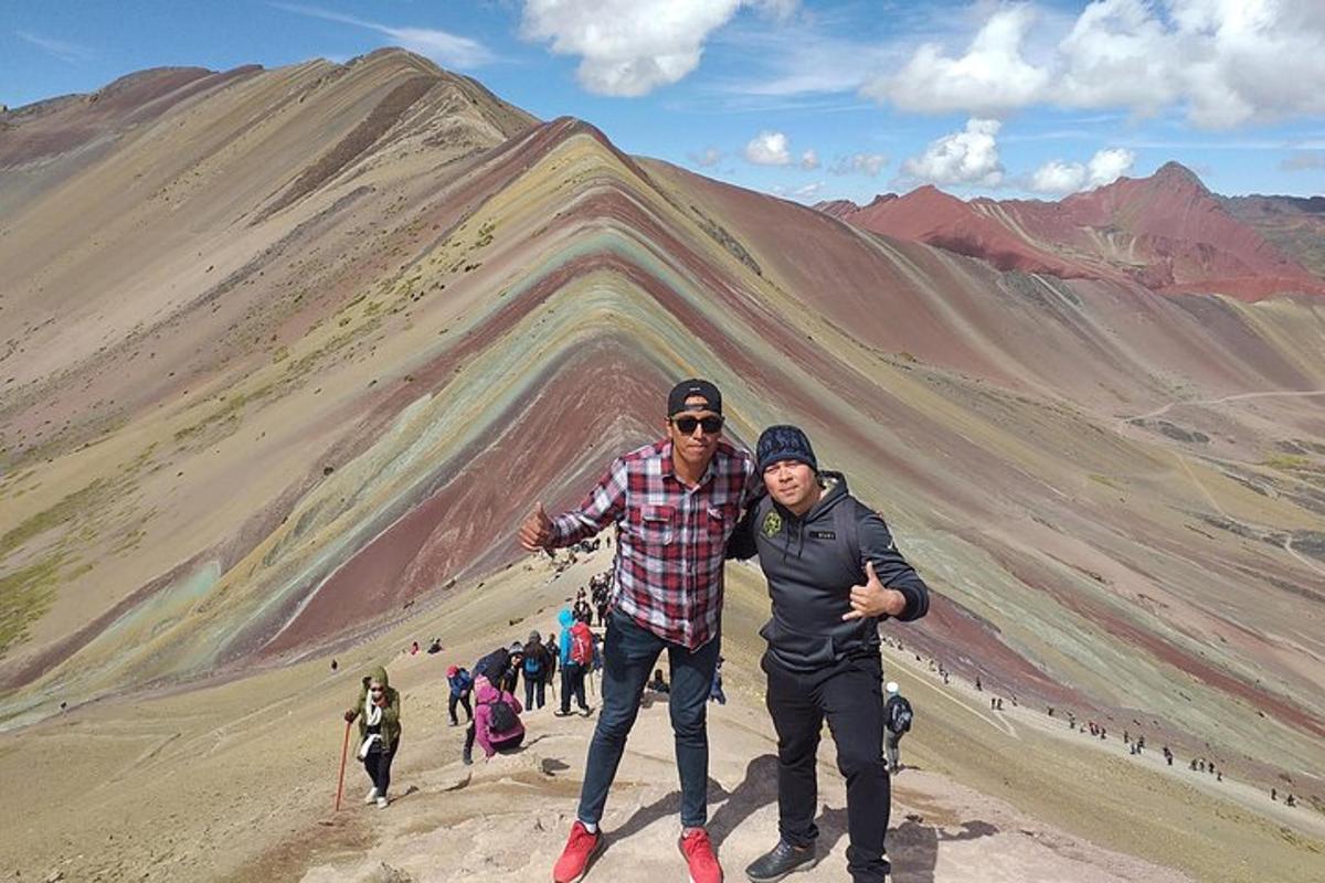 dua orang berdiri di depan gunung