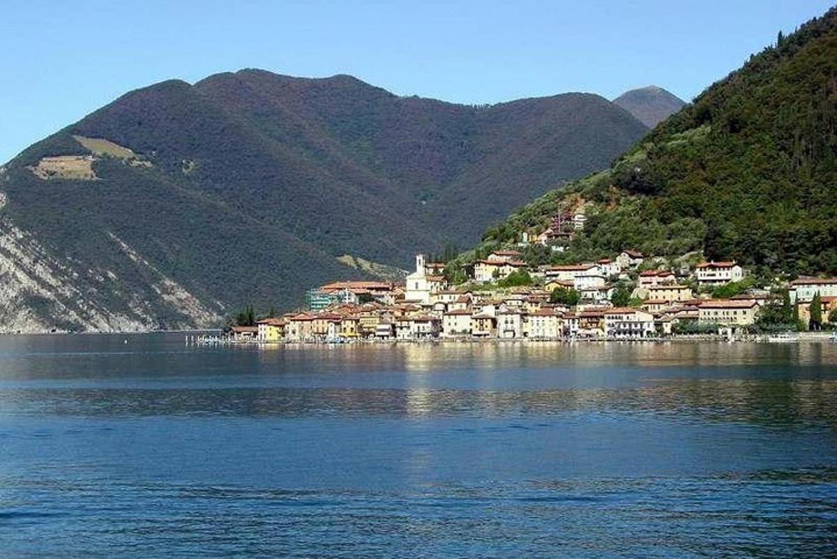 a town on the shore of a lake with mountains