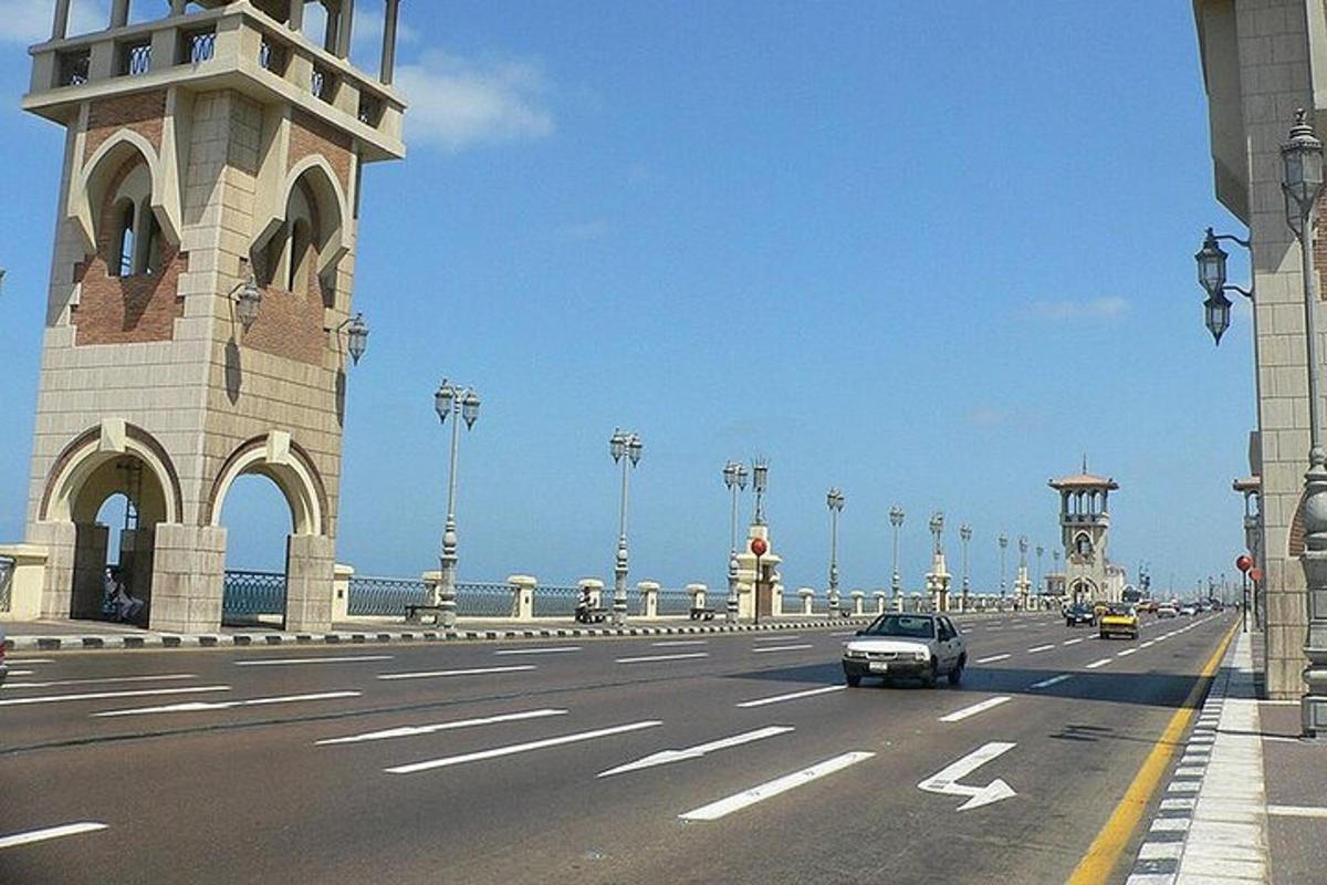 một chiếc xe đang chạy trên đường bên cạnh một cây cầu