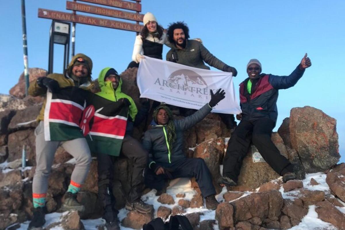 un gruppo di persone in piedi sulla cima di una montagna