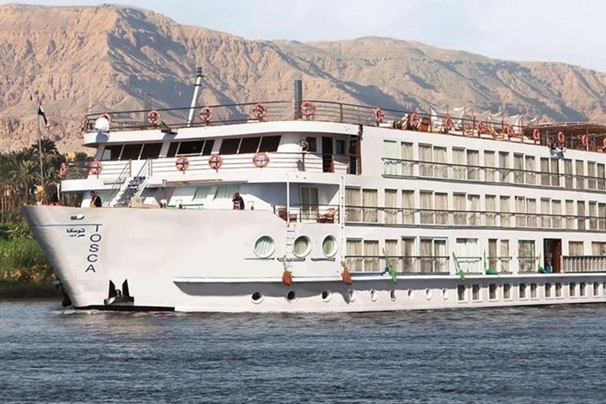 una nave da crociera sull'acqua con le montagne sullo sfondo