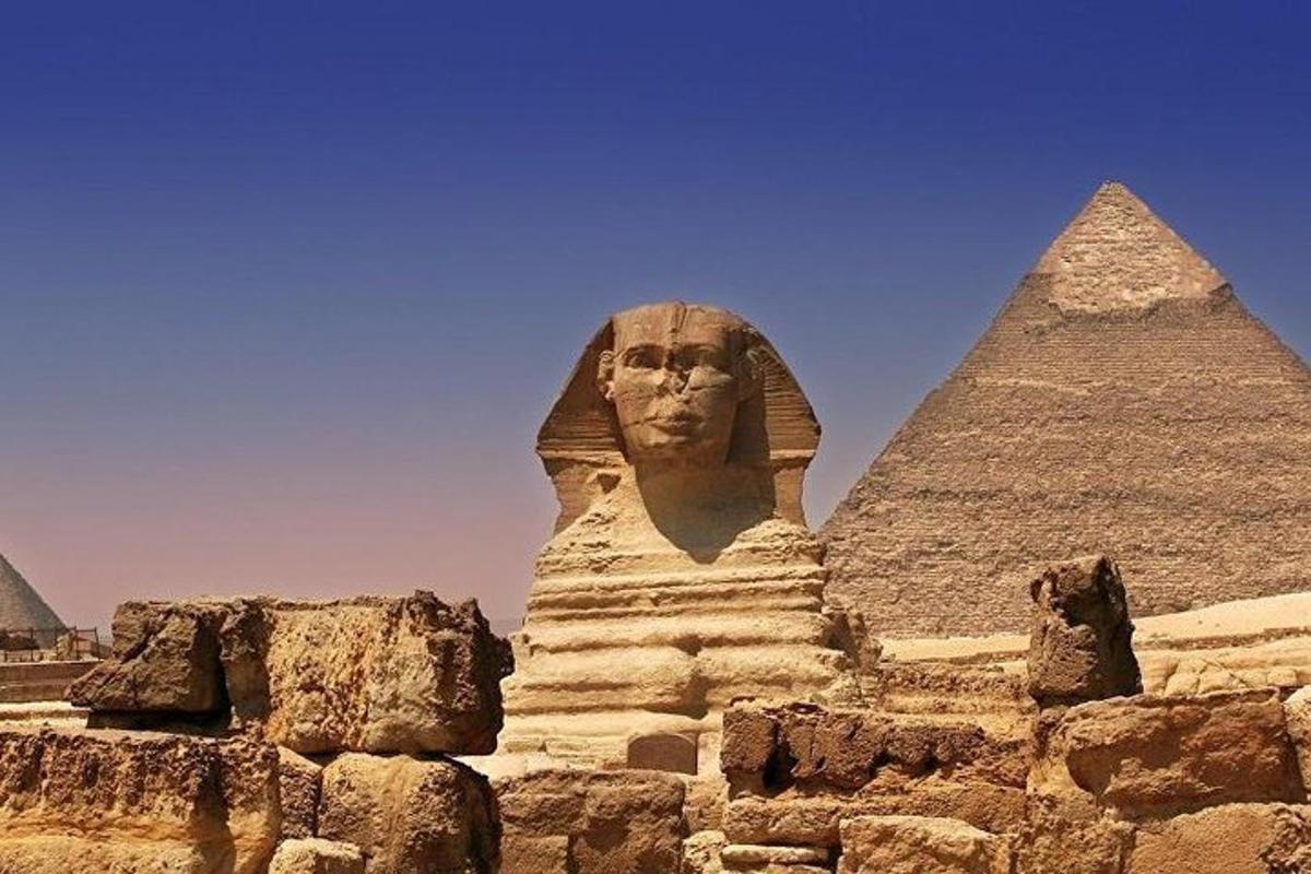 một bức tượng của anubis ở phía trước các kim tự tháp