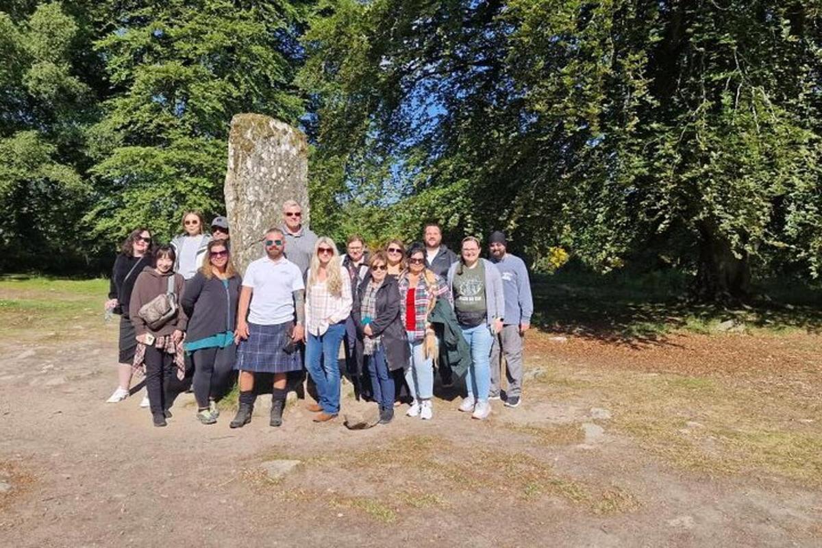 a group of people posing for a picture in front of a monument