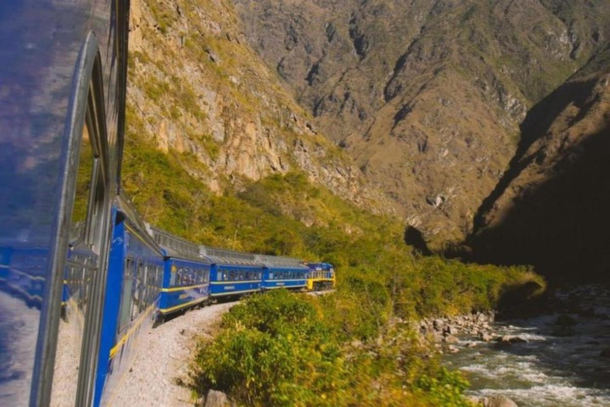 a blue and yellow train traveling down a mountain