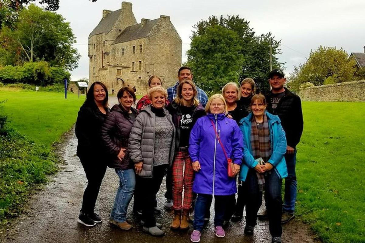 a group of people posing for a picture in front of a castle