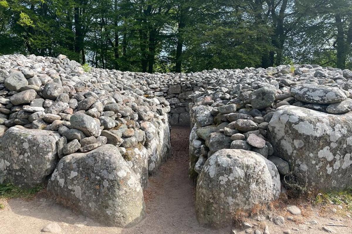 um muro de pedra com rochas e árvores ao fundo