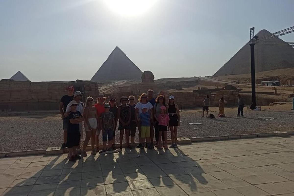 skupina lidí stojící před pyramidami