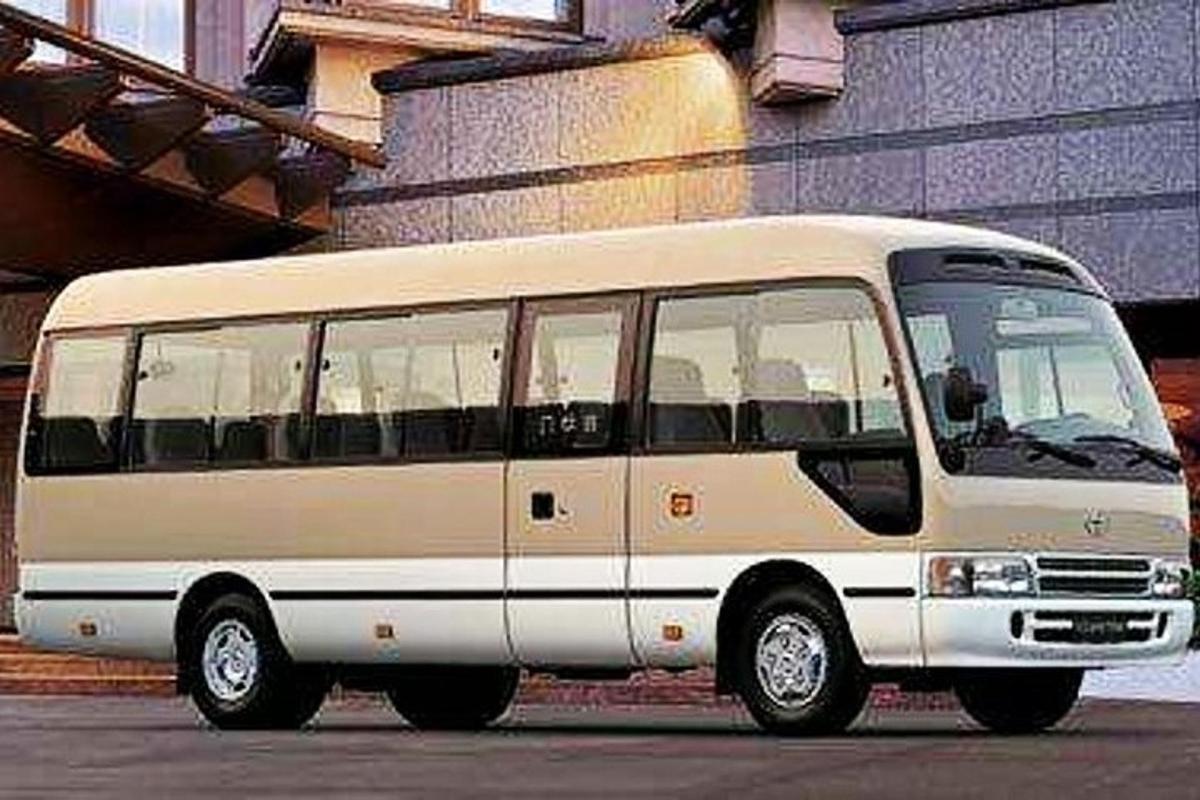 bílý autobus zaparkovaný před budovou
