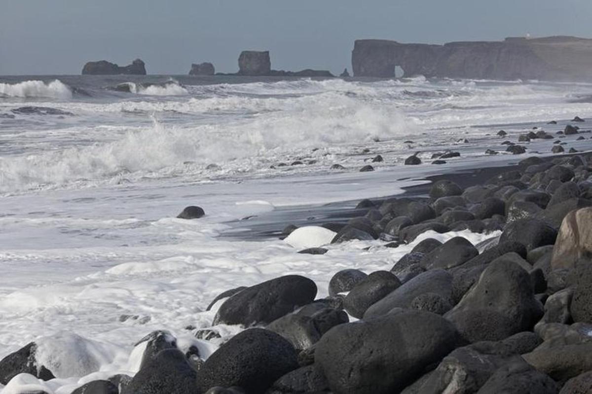 una playa rocosa con olas y rocas en el océano
