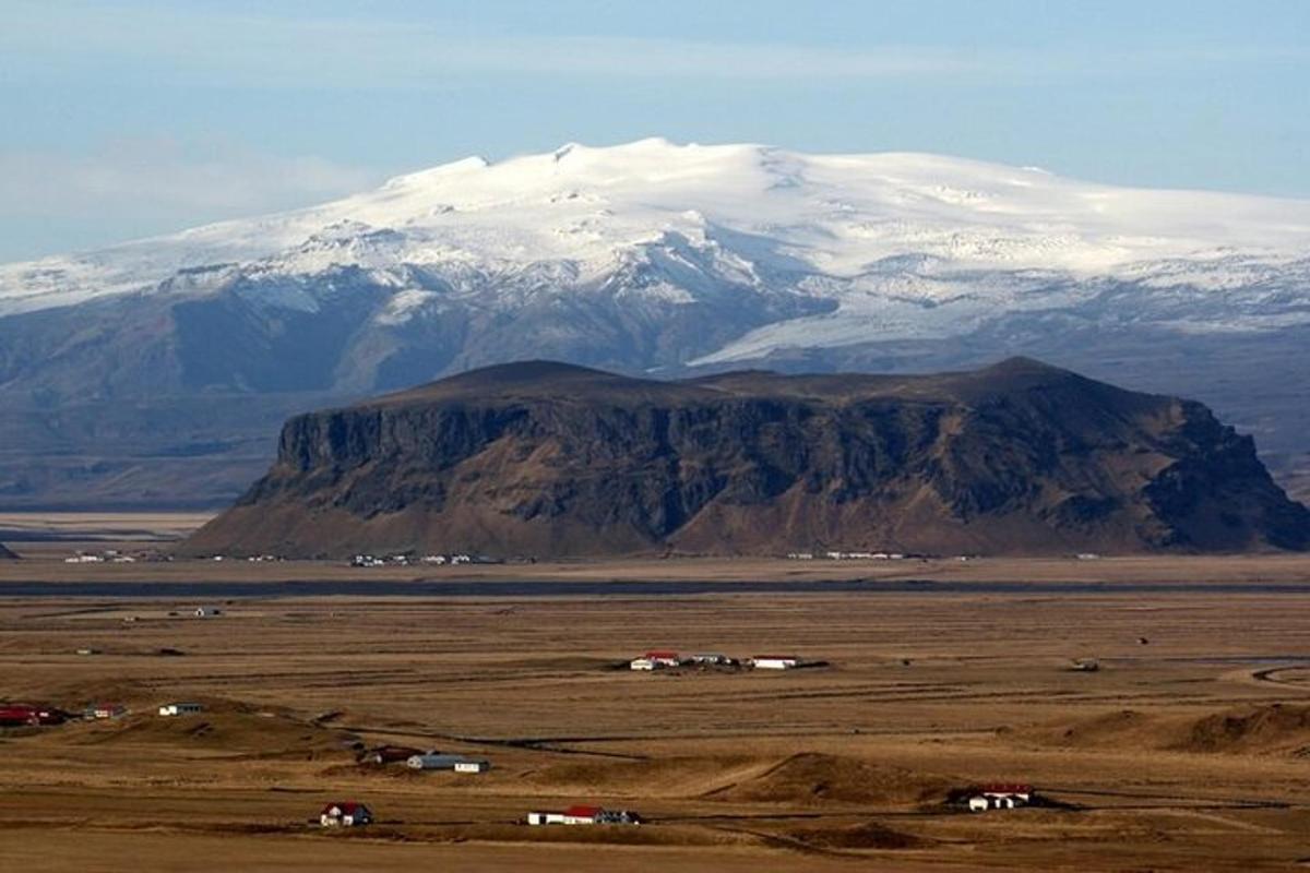 Una montaña con montañas cubiertas de nieve en la distancia