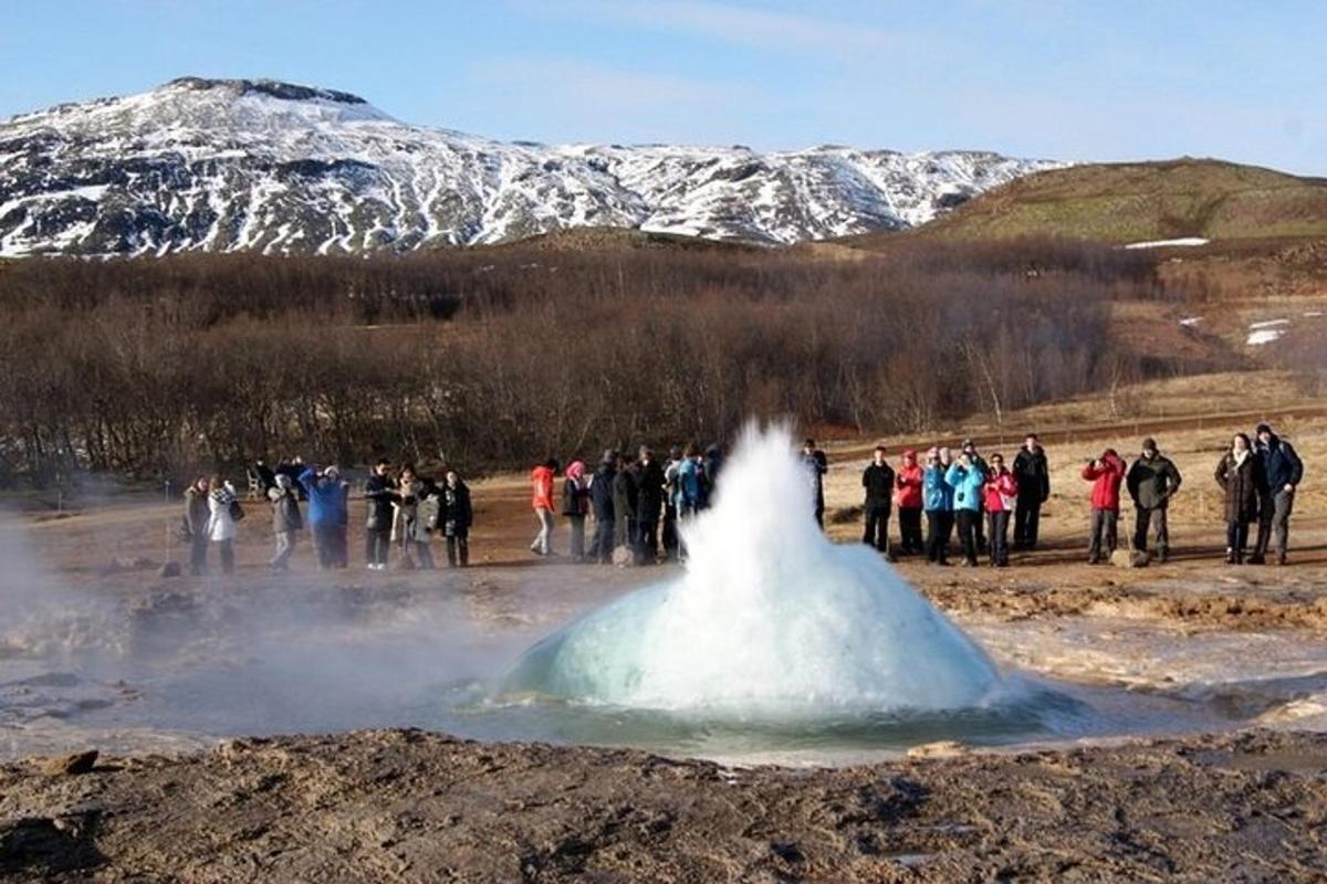 Un grupo de personas de pie alrededor de un montón de nieve.