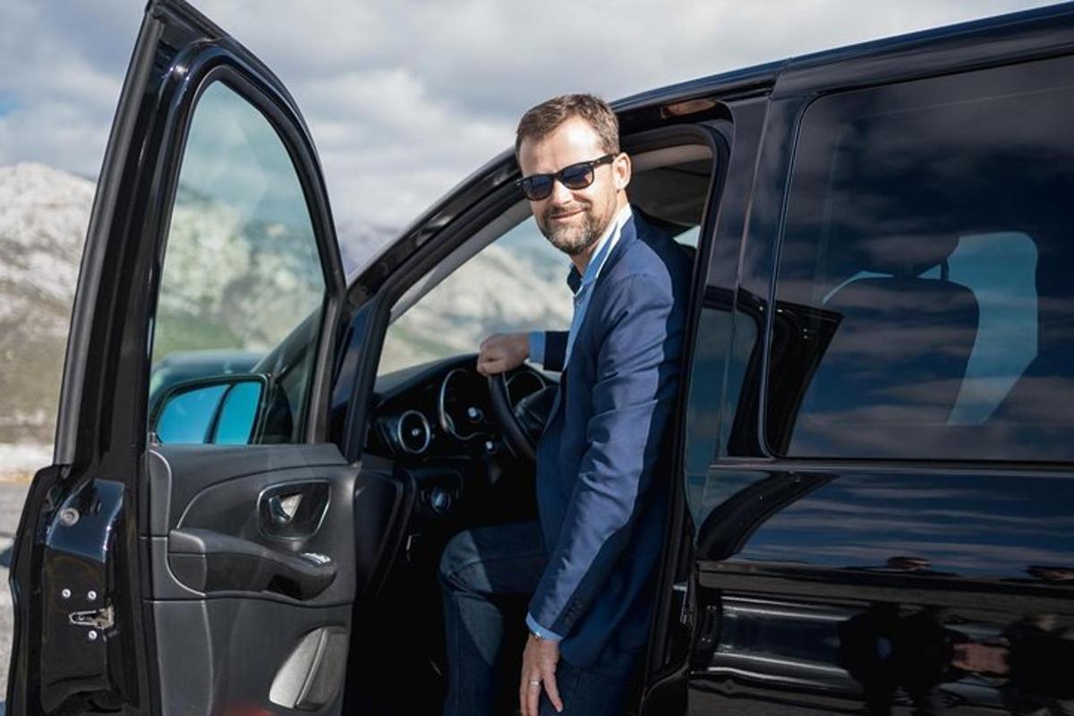 en mann i dress som går ut av en varebil