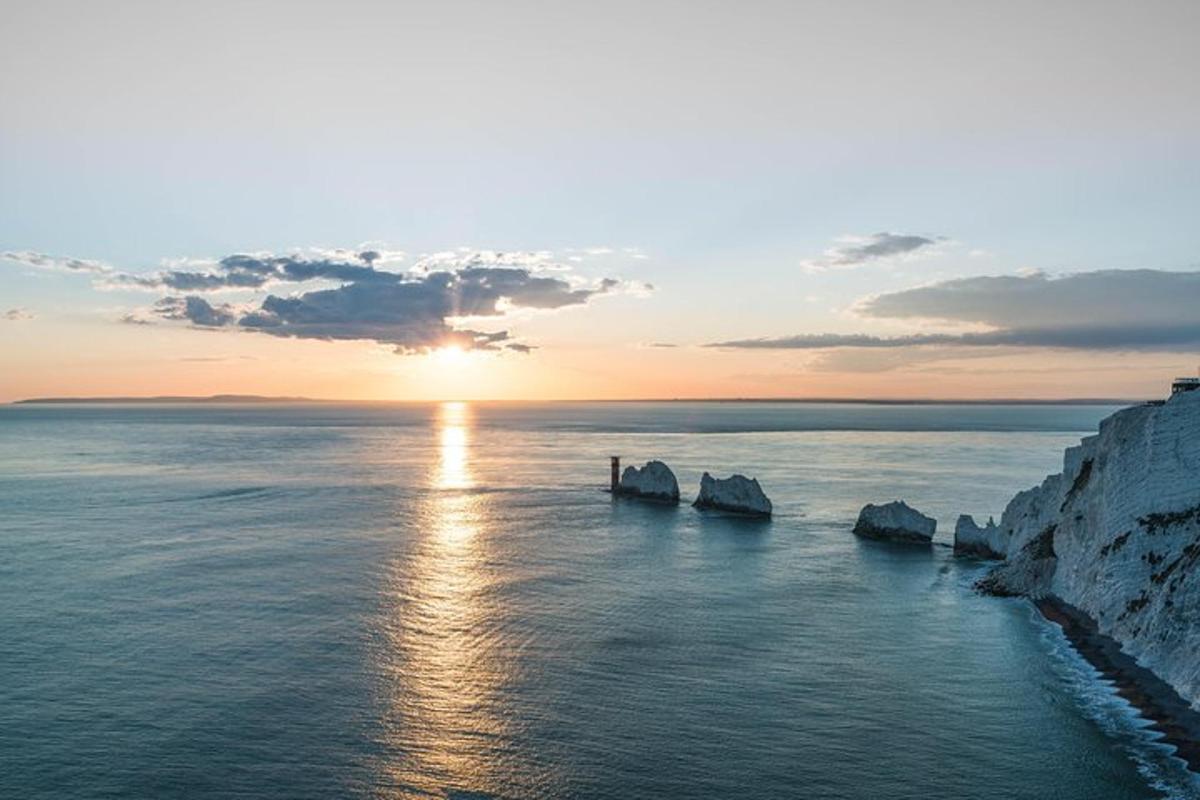 un coucher de soleil sur l'océan avec des rochers dans l'eau