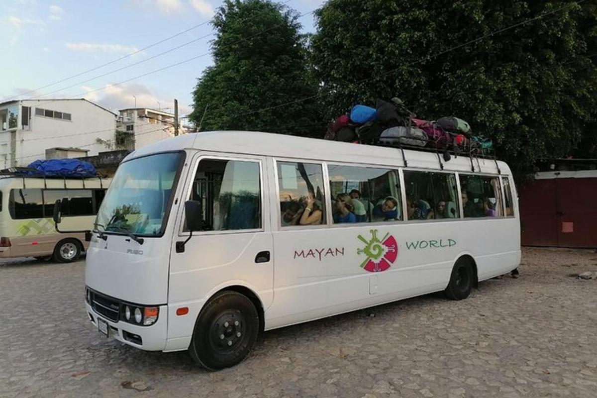 a white bus with people sitting on top of it