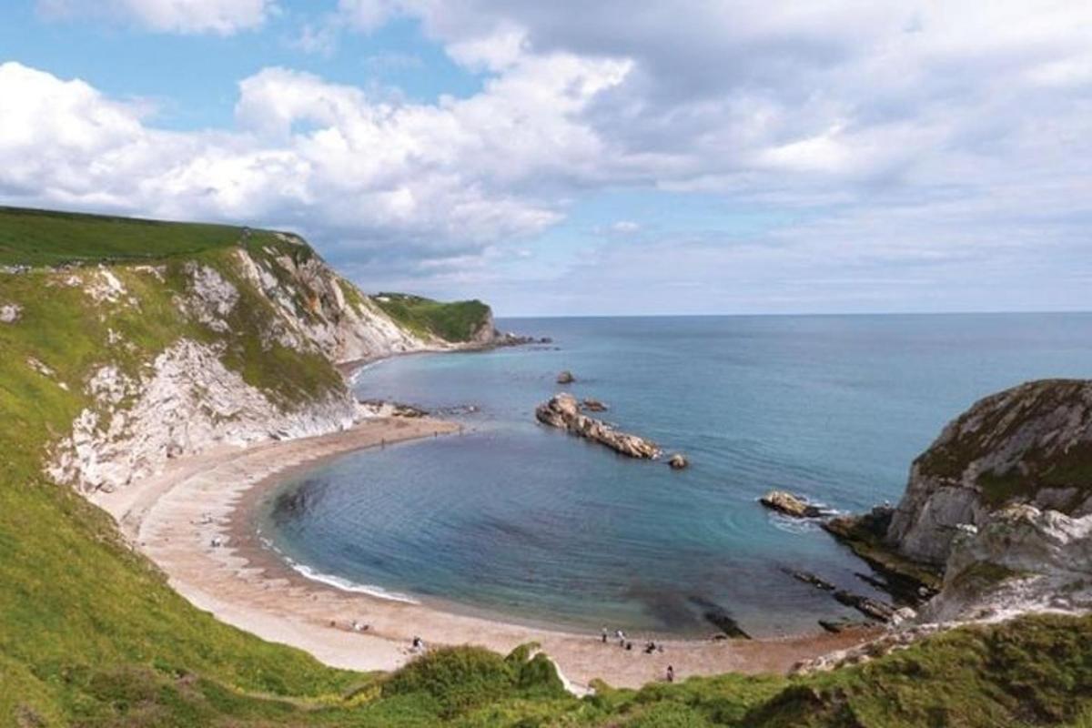 a beach with people on the sand and the water