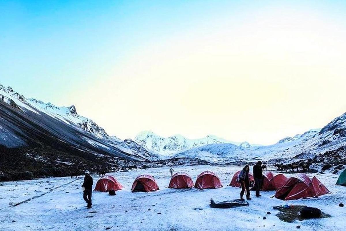 a group of people standing in the snow with tents
