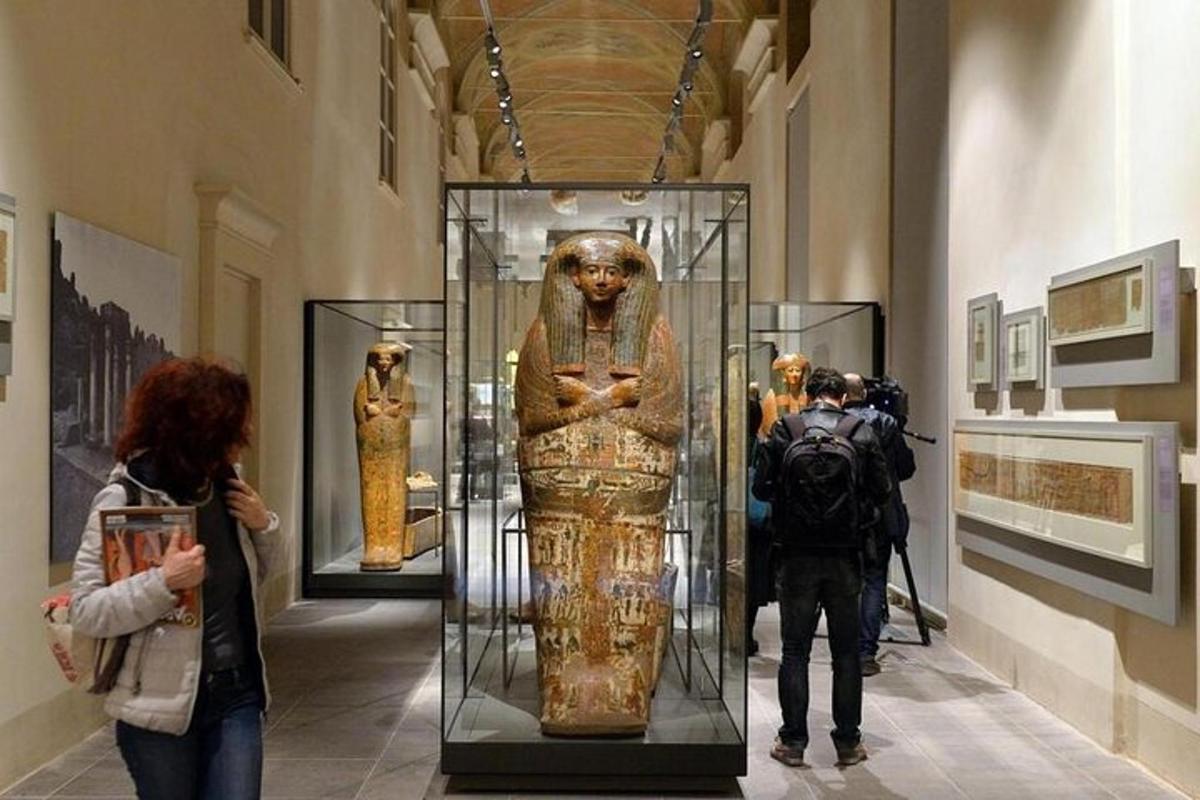 Un grupo de personas mirando una estatua en un museo.