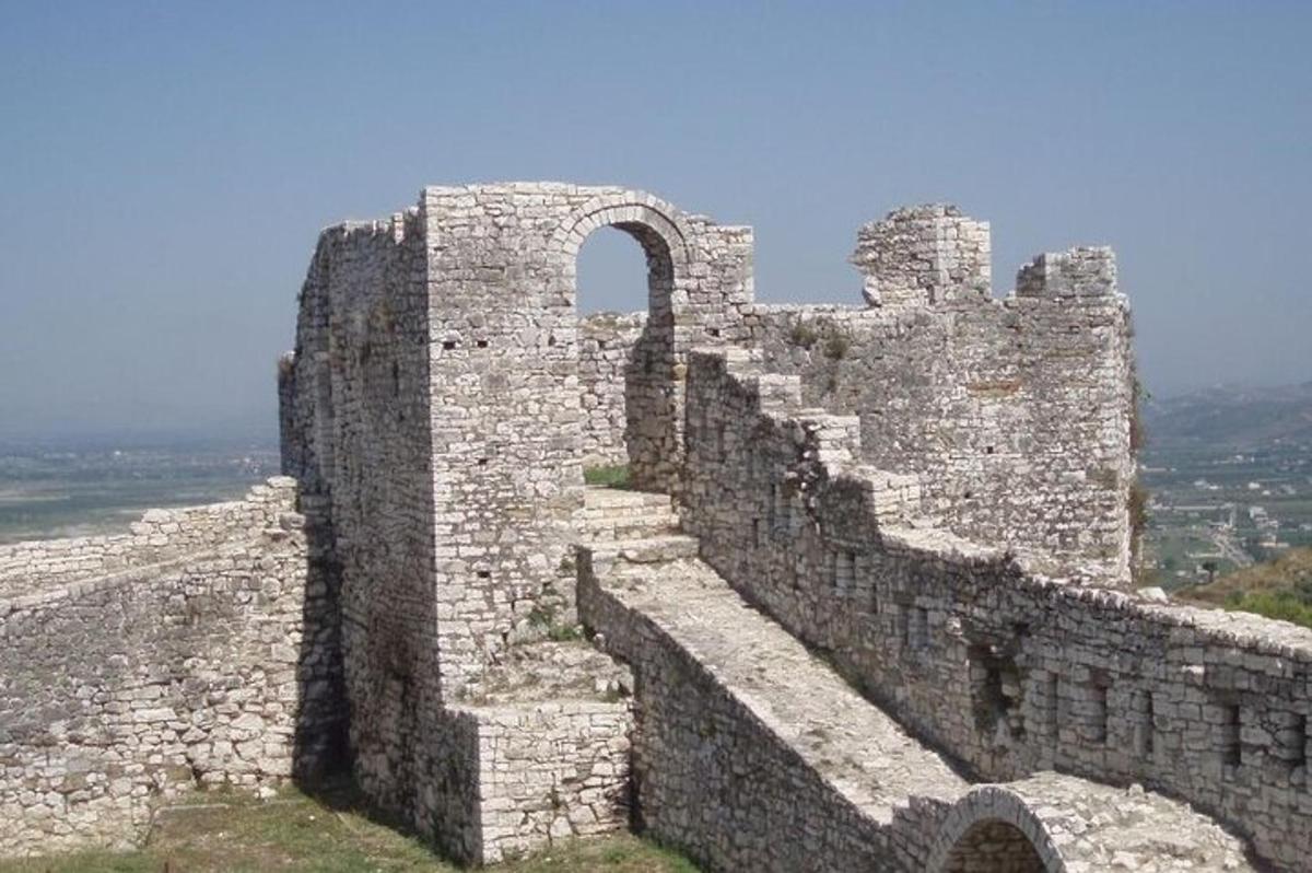 an old stone building with an arch on top of it