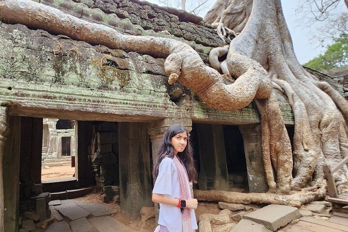 a woman standing in front of a building with a tree