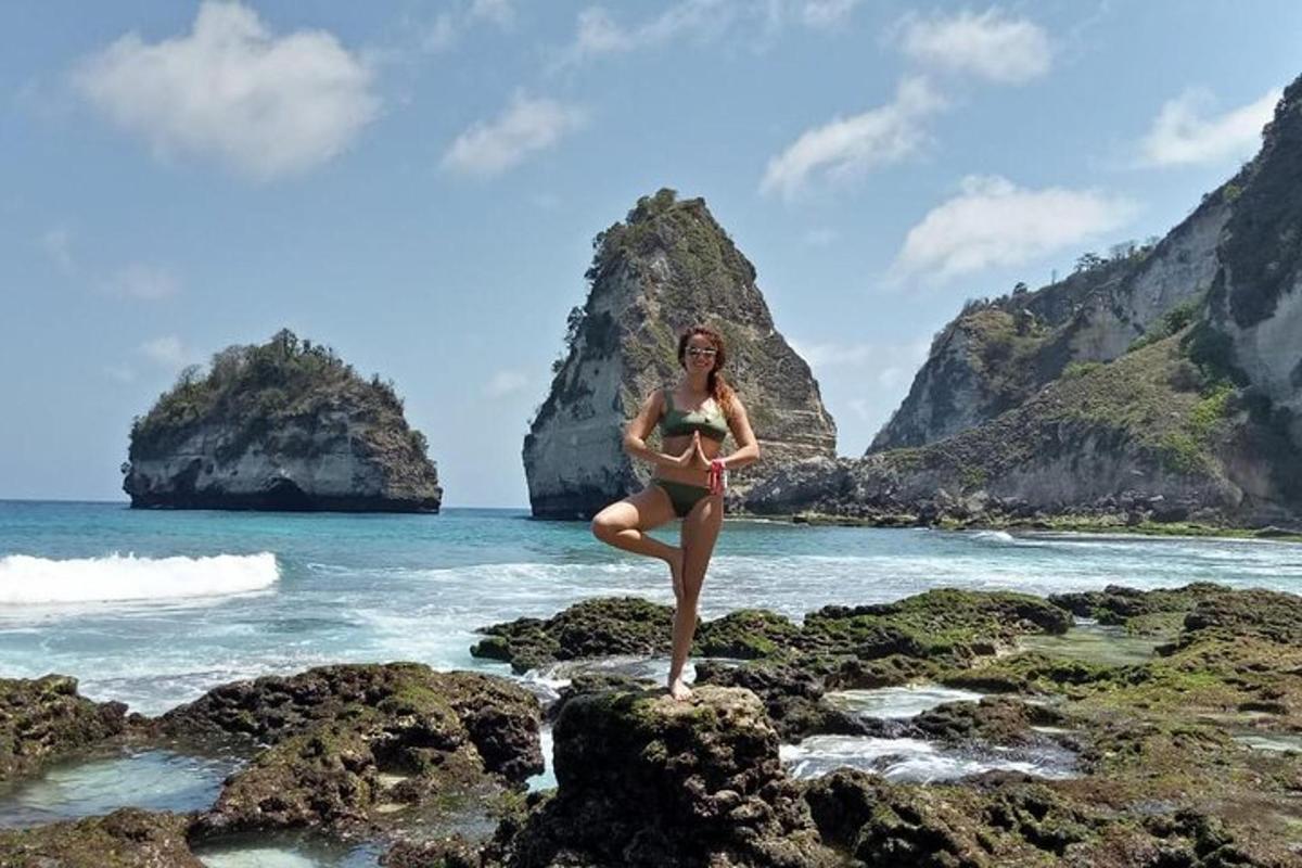 en kvinde i bikini, der står på klipper på stranden