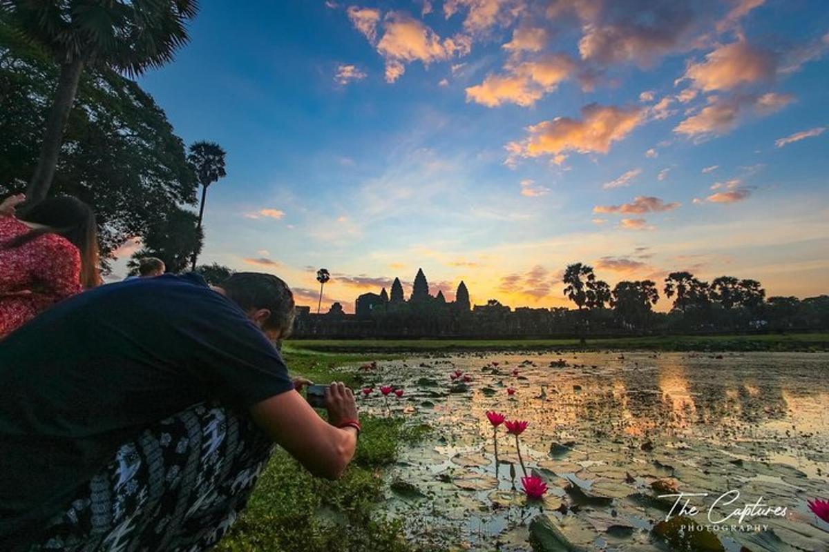 Un hombre y una mujer mirando un estanque de flores.