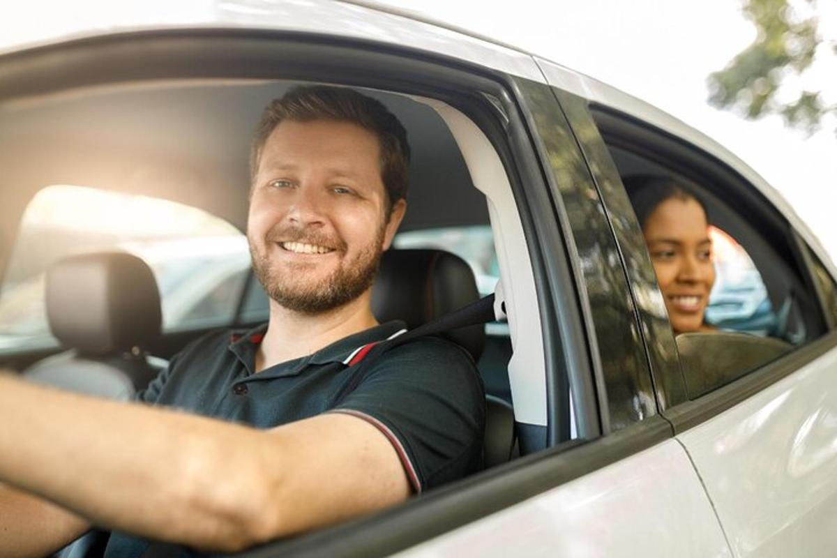 vyras sėdi automobilyje su vaiku gale