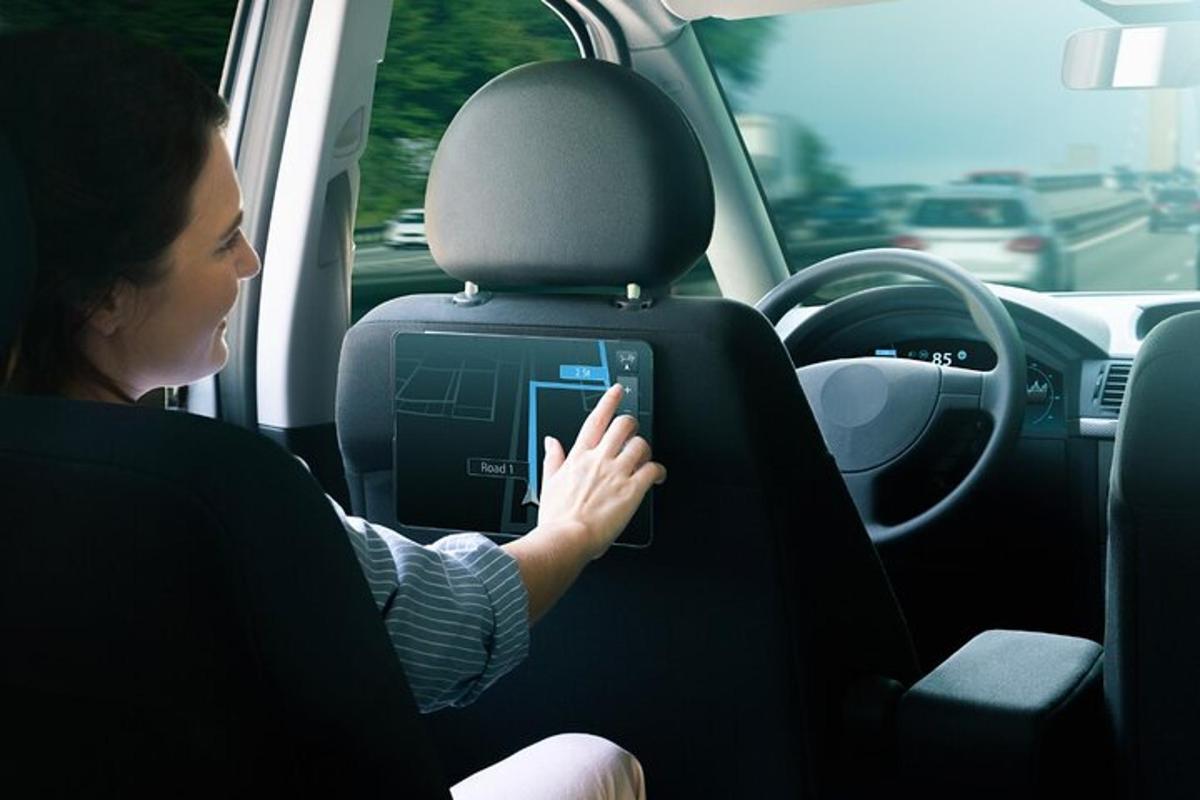une femme assise dans une voiture utilisant une tablette