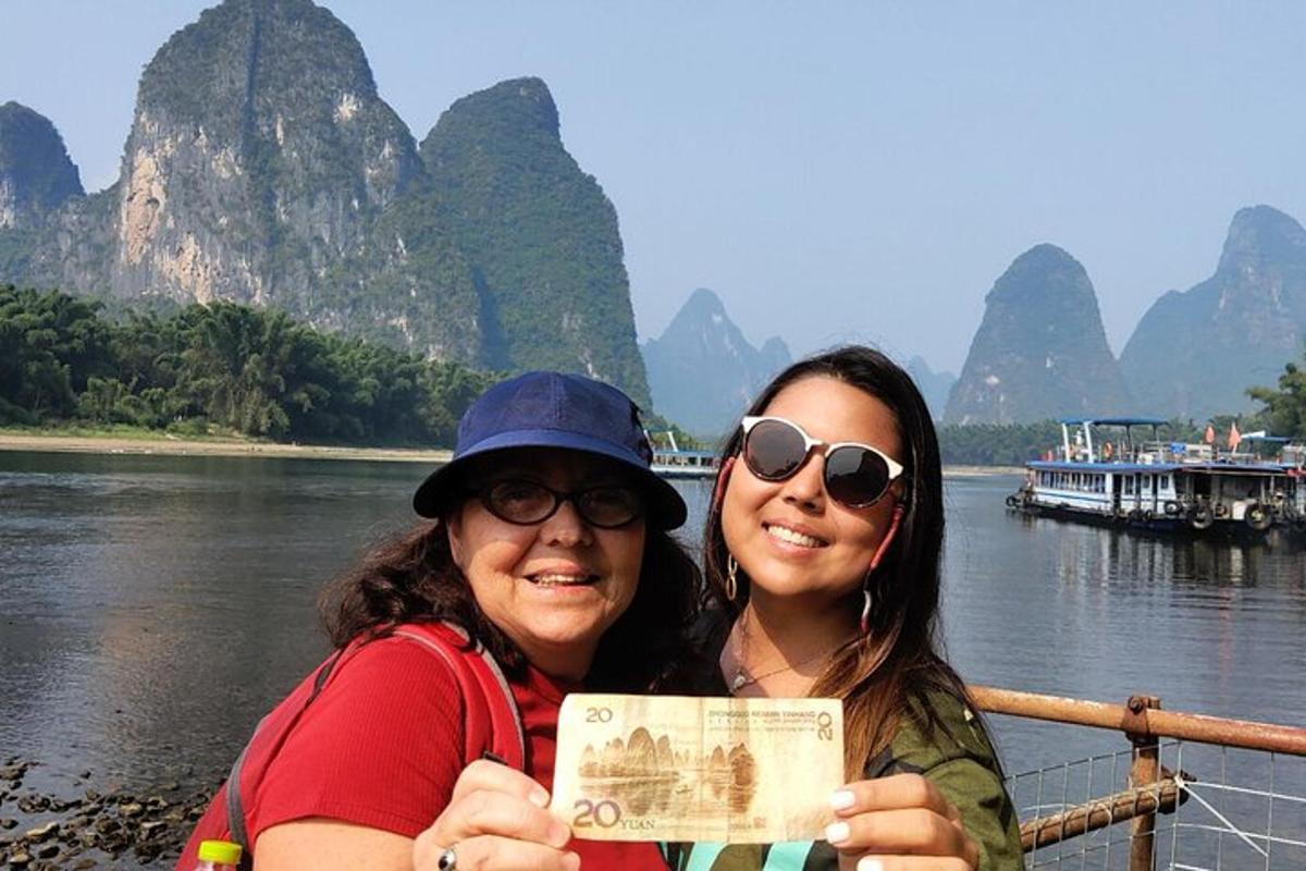 two women standing on a boat on the river