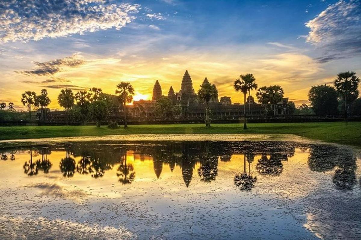 a sunset over a pond in front of a temple