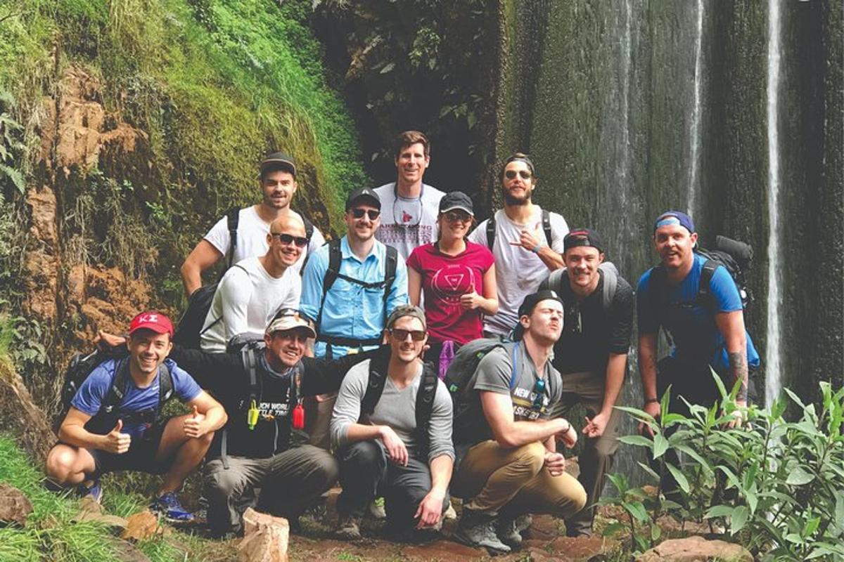 un grup de oameni care pozează pentru o fotografie în fața unei cascade