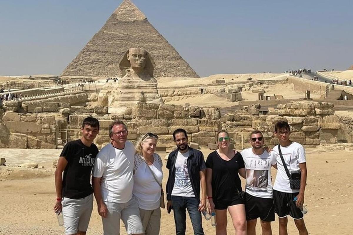 skupina ľudí stojaca pred pyramídami