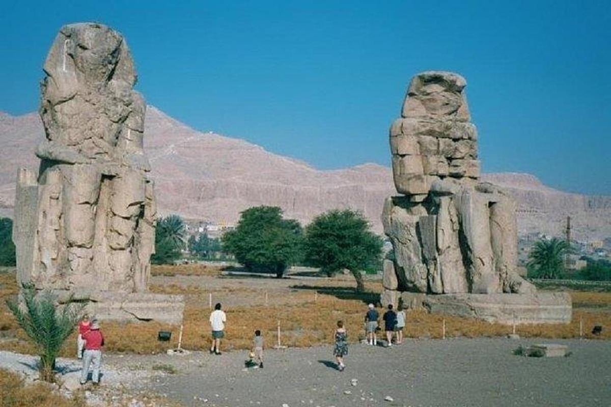 مجموعة من الأشخاص يقفون أمام تمثالين