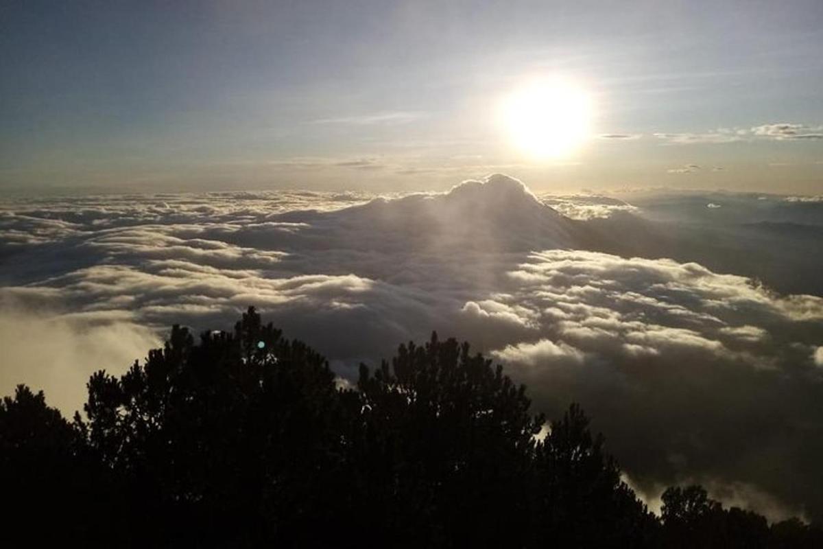 太阳高悬云层之上的山景