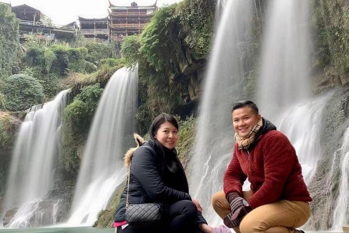 dua orang duduk di depan air terjun