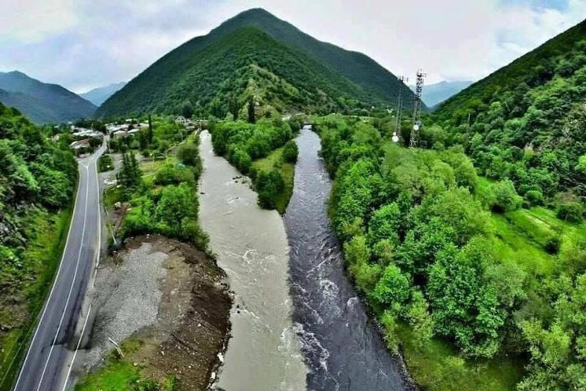 uma vista aérea de um rio próximo a uma montanha