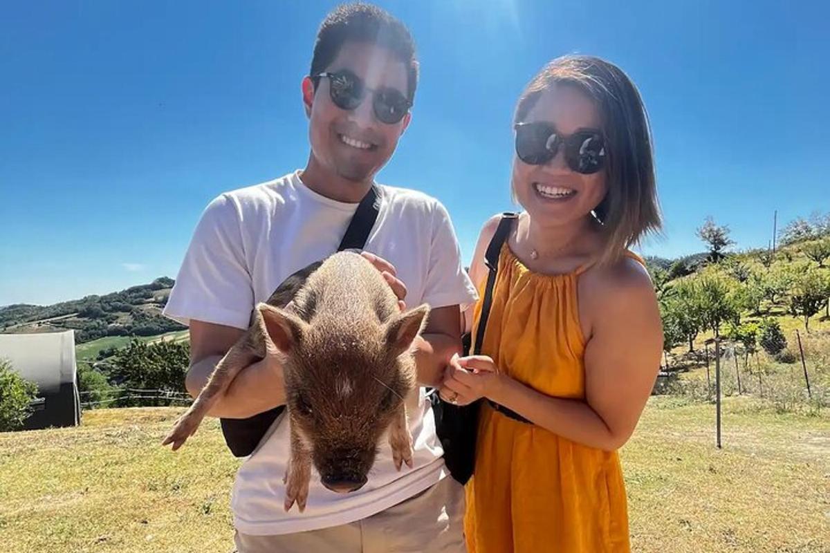 um homem e uma mulher segurando um porquinho