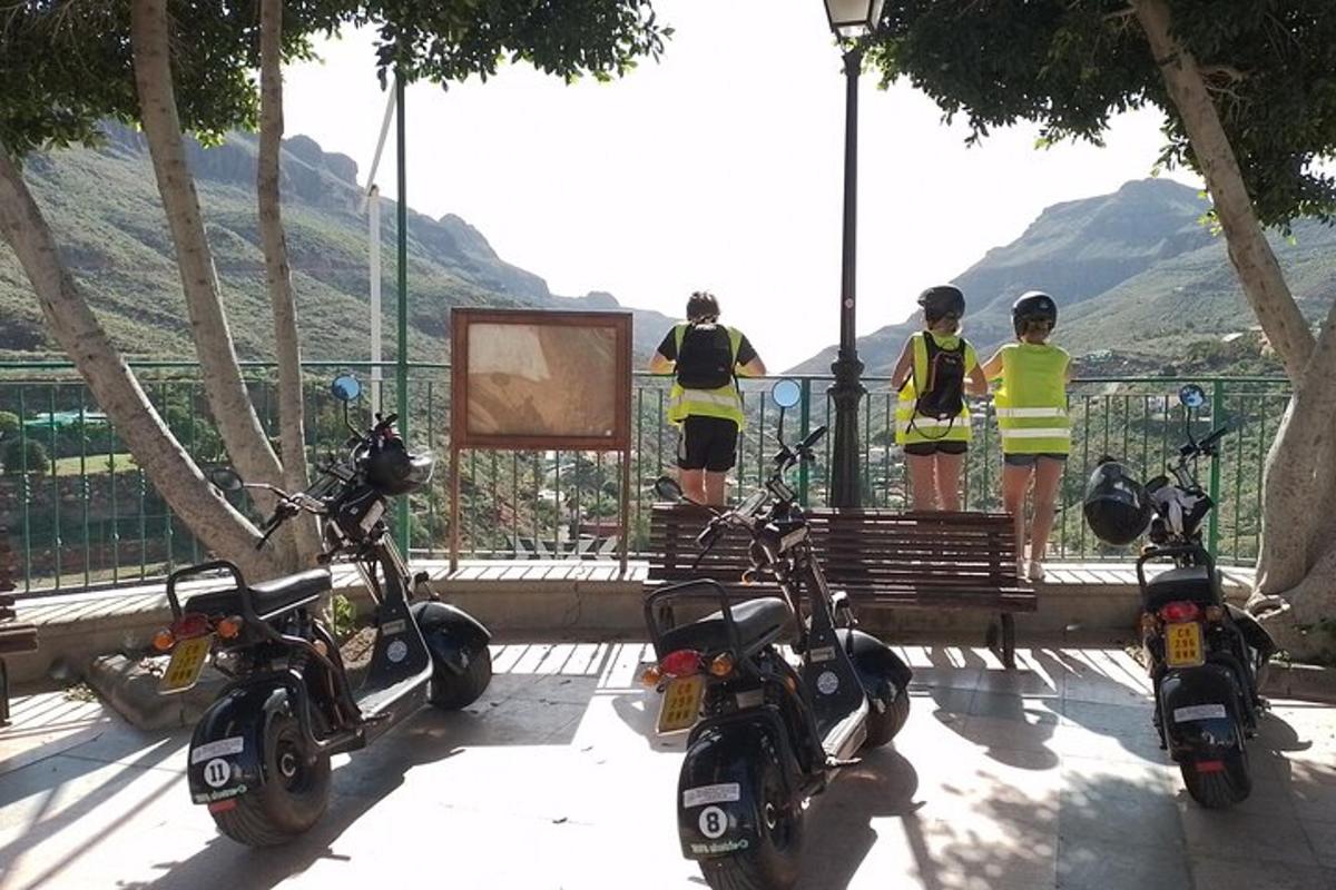 một nhóm ba chiếc xe tay ga đậu cạnh một chiếc ghế dài