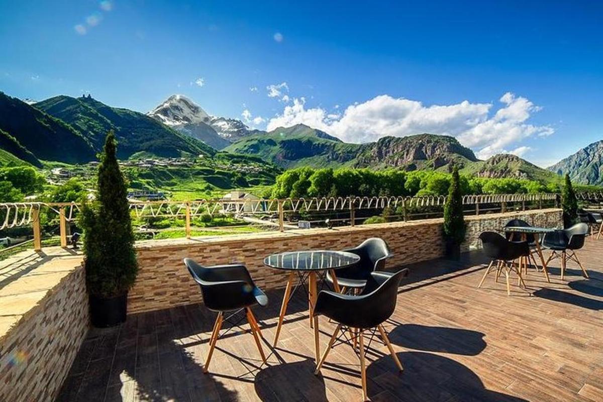 un patio con tavolo, sedie e montagne