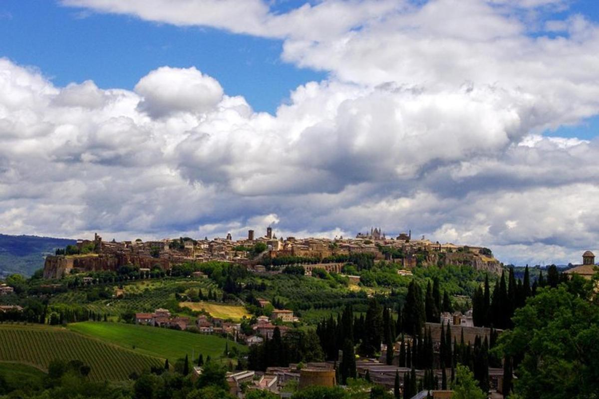 a town on top of a hill under a cloudy sky