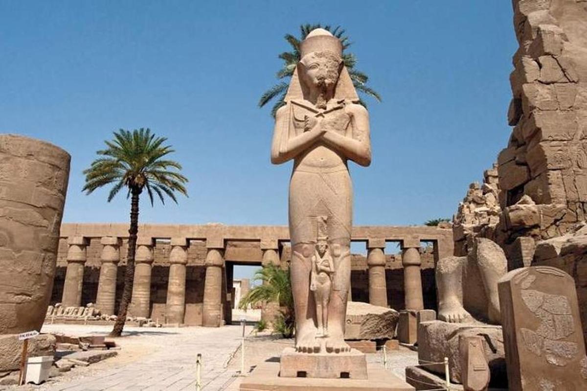 uma estátua de uma mulher em pé em frente a um prédio
