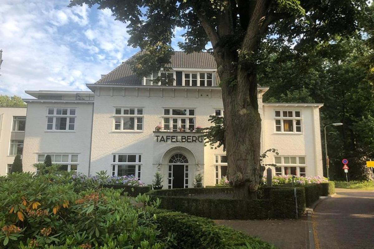 ein weißes Gebäude mit einem Baum davor
