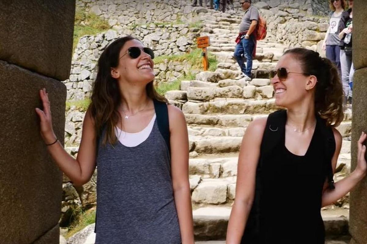 due donne sono in piedi davanti ad alcune rovine