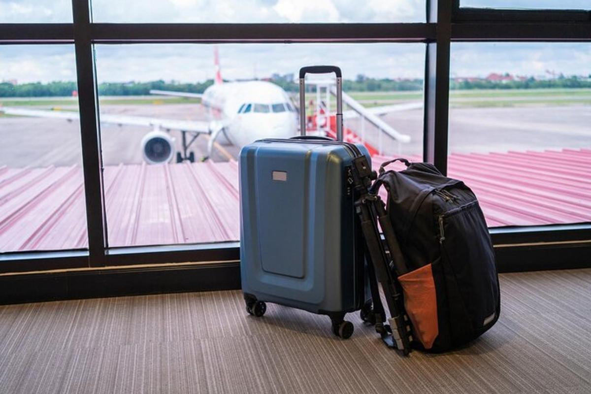 două bagaje așezate lângă geamul aeroportului