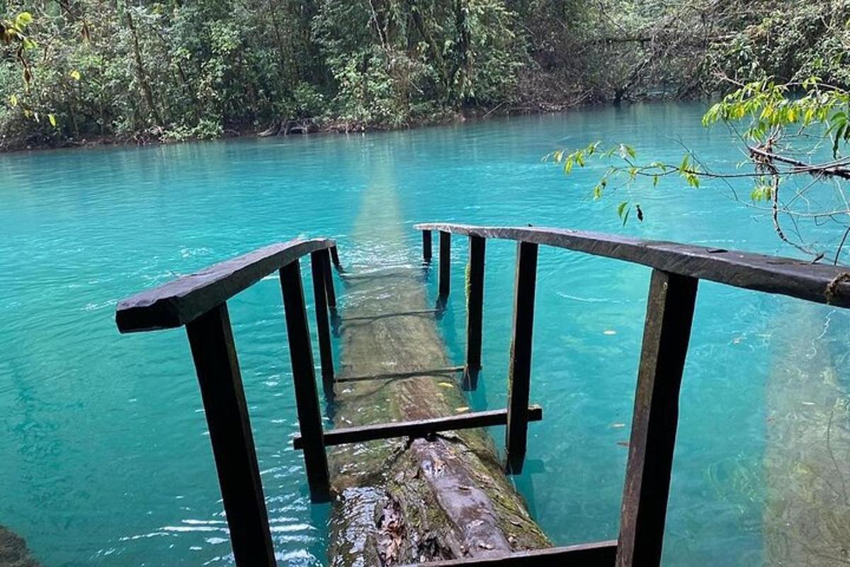 a wooden bridge over a river with blue water