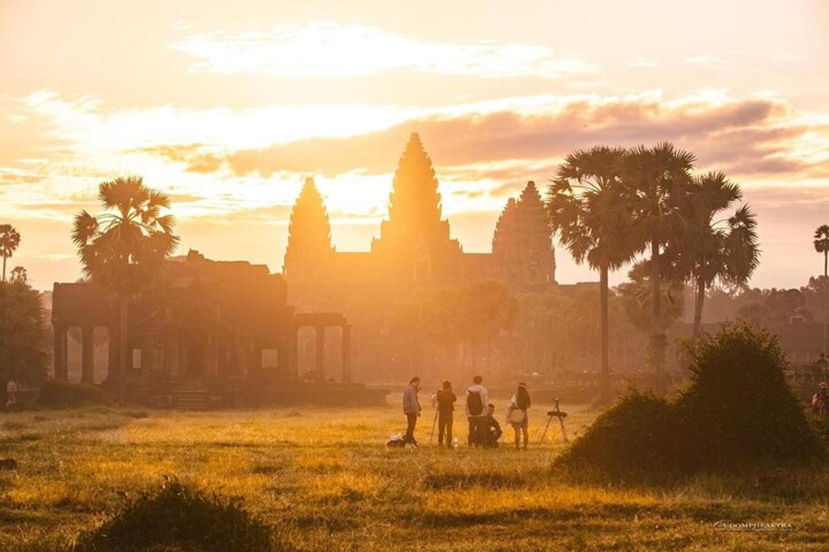 a group of people standing in a field in front of a temple